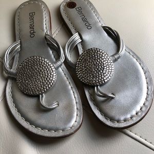 Silver flip flops with rhinestone medallion on top